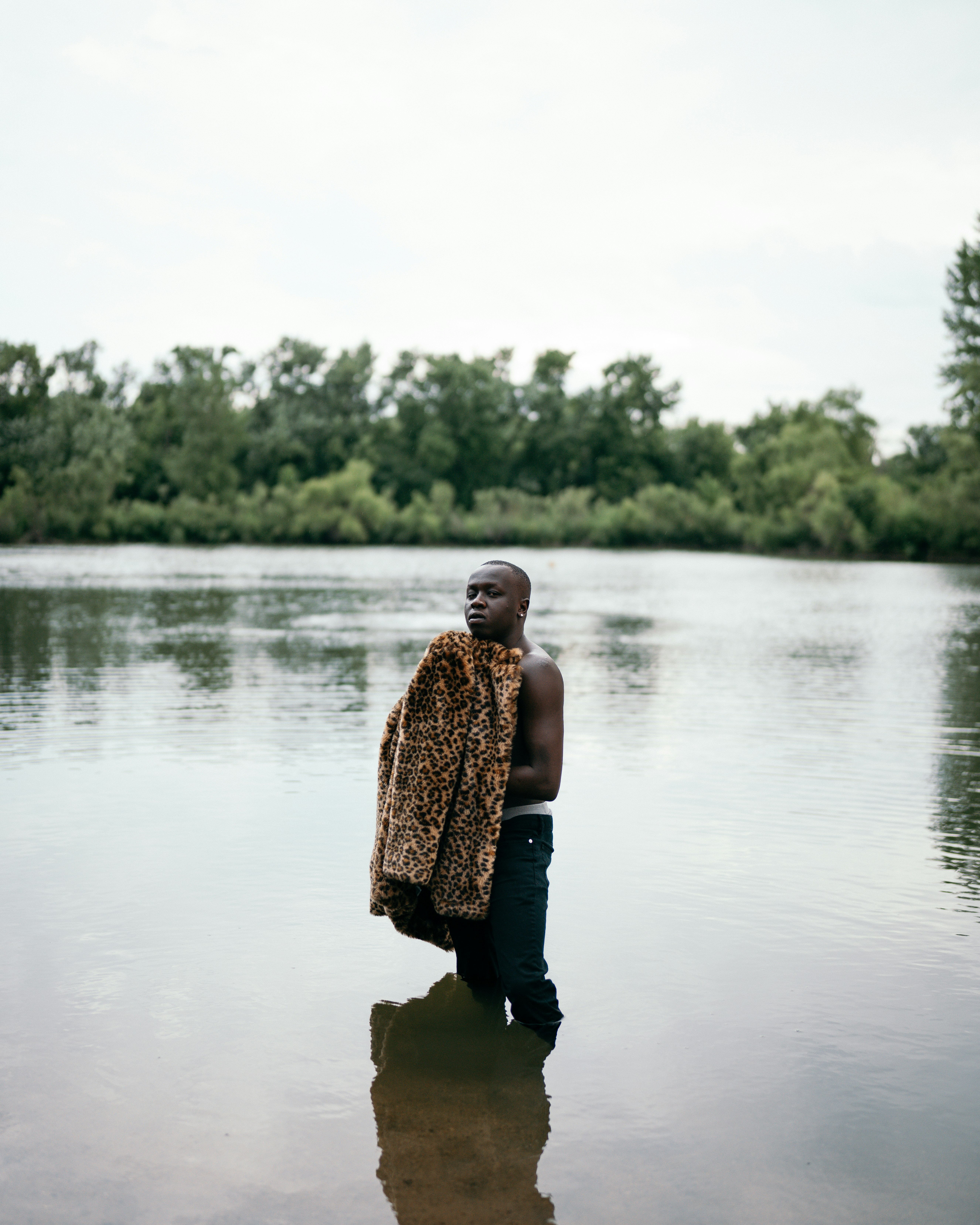 woman in brown and black leopard print dress standing on lake during daytime